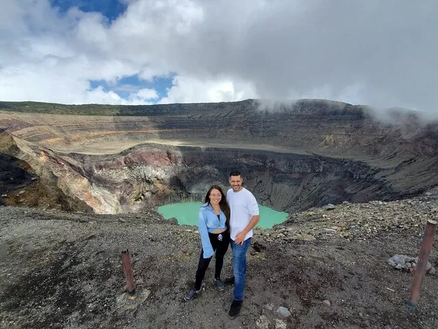 Una pareja posa junto al lago turquesa del cráter del Volcán Santa Ana.