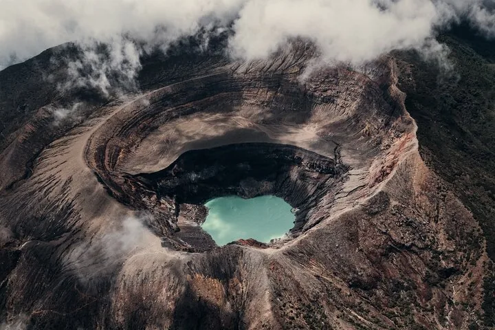 Vista aérea del cráter del Volcán Santa Ana con su distintivo lago turquesa en su interior.