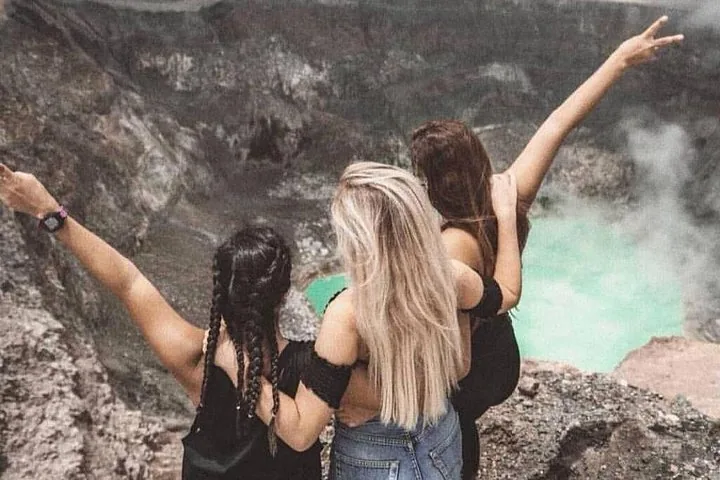 Tres mujeres con los brazos levantados contemplando el cráter del Volcán Santa Ana